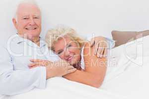 Cheerful couple lying on the bed