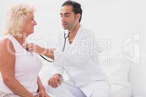 Doctor examining an old woman