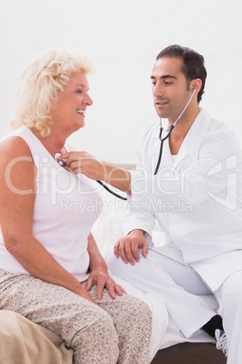 Doctor examining a smiling old woman