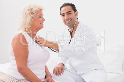 Smiling doctor examining an old woman