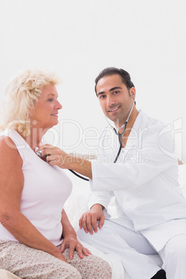 Cheerful doctor examining an old woman