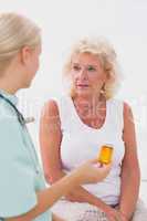 Doctor talking about a pill bottle to her patient