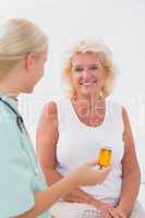 Nurse talking about a pill bottle to her smiling patient