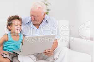 Grandfather and his grandson watching a laptop screen