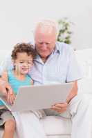 Grandfather and grandson watching a laptop