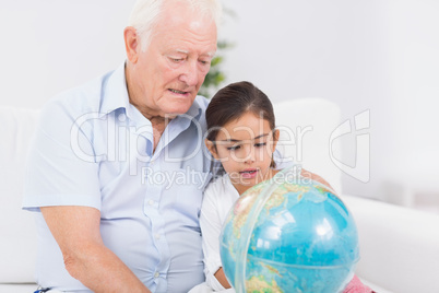 Granddaughter and grandfather with globe