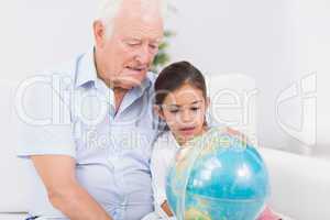 Granddaughter and grandfather with globe