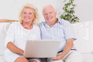 Old couple using a laptop together