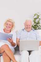 Old couple using a laptop and the tablet