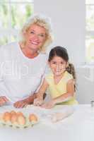 Granddaughter and grandmother preparing biscuits together
