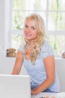 Woman smiling at the camera with a computer