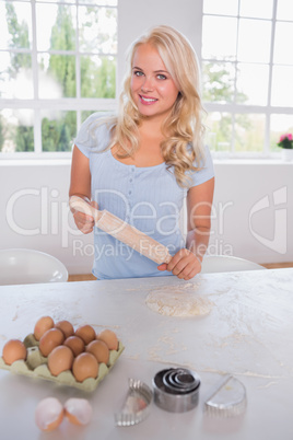 Smiling woman with a rolling pin and ingredients