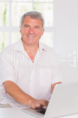 Old man using a white laptop