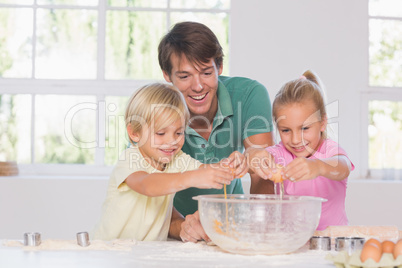 Children breaking eggs into a bowl