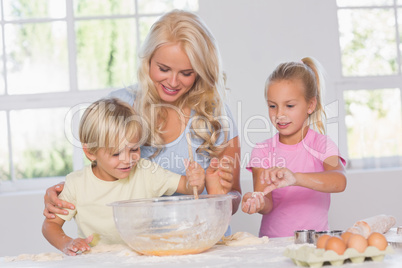 Children mixing dough with their mother