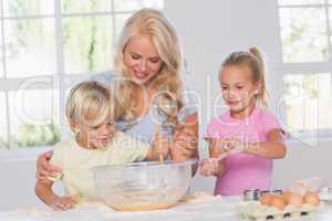 Children mixing dough with their mother