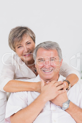 Old lovers smiling at the camera and hugging