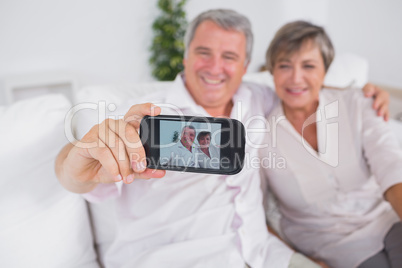 Old man taking a photo of him and his wife