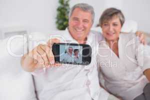 Old man taking a photo of him and his wife