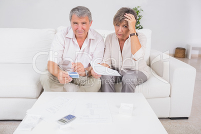 Old stressed couple calculating bills