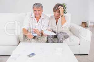 Old stressed couple calculating bills