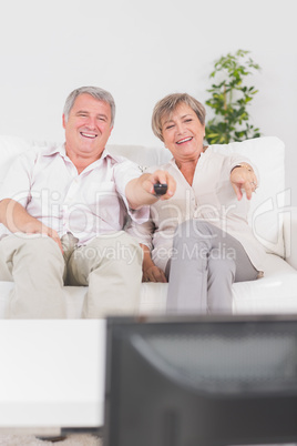 Old couple watching TV and pointing