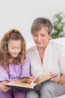 Little girl and her grandmother reading a book