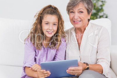 Little girl and her grandmother looking at the camera with table