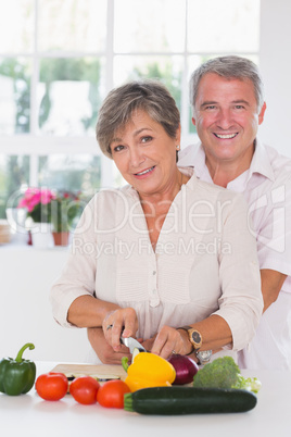 Portrait of a woman cutting vegetables with her â€&#