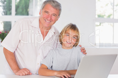 Grandfather and child looking at the camera with smile in front