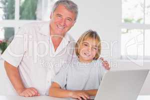 Grandfather and child looking at the camera with smile in front