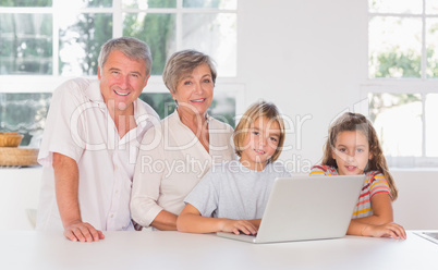Children and grandparents looking at the camera together with la
