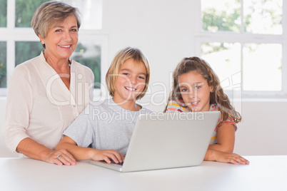 Grandmother and children looking at the camera together with lap