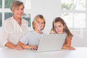 Grandmother and children looking at the camera together with lap