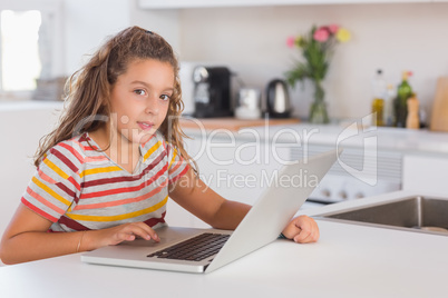 Smiling child looking at the camera with laptop