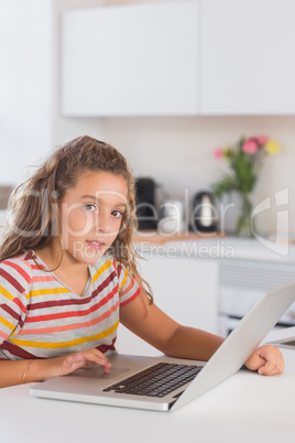 Child looking at the camera with laptop