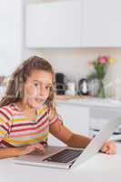 Child looking at the camera with laptop