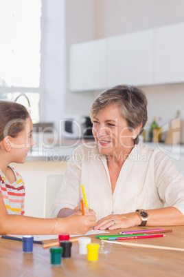 Smiling child with her granny drawing