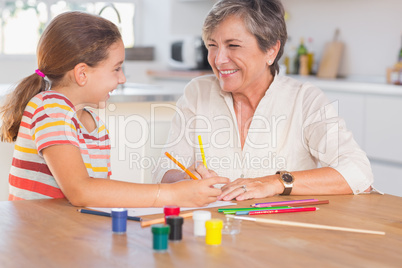 Child with her granny drawing and laughing