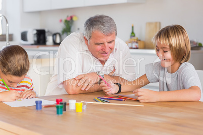 Grandfather and her grandchildren drawing