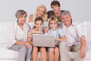 Family portrait looking at camera with a laptop
