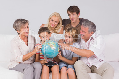 Family looking at globe on couch