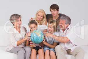 Family looking at globe on couch