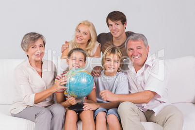 Family portrait looking at camera with a globe