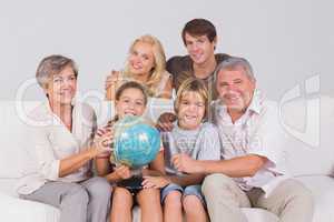 Family portrait looking at camera with a globe