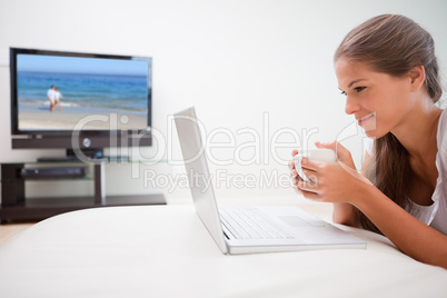 Woman surfing the internet while having a cup of coffee