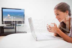 Woman surfing the internet while having a cup of coffee