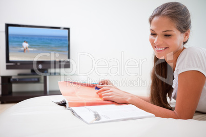 Smiling woman reading a magazine on the sofa