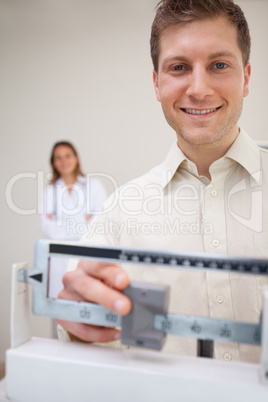 Smiling man adjusting scale