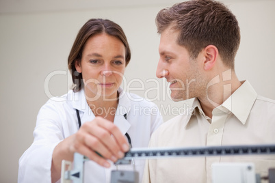 Doctor adjusting scale for her patient